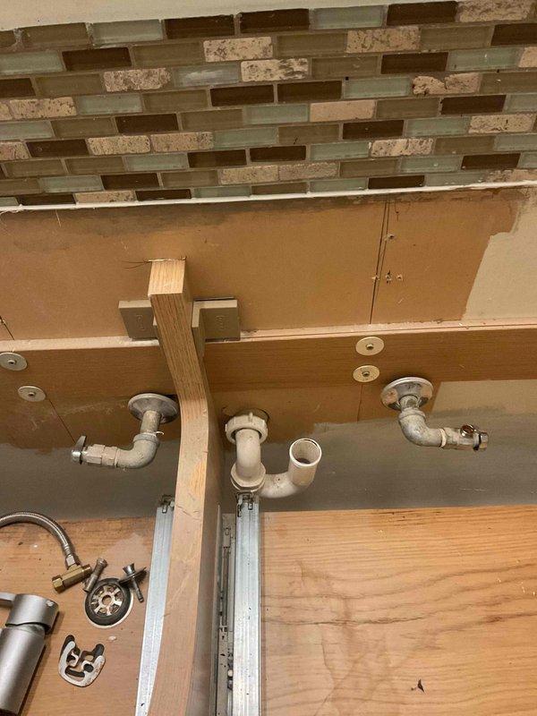 Completed installation of a double bowl sink with new strainers and tubular drain assembly. Assembled and connected all P-trap components and drain piping beneath the bathroom vanity. Work was performed according to quoted specifications and verified proper drainage before completion.