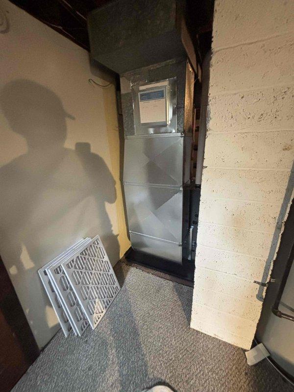 Successfully installed new residential furnace system in basement utility area, including proper connection of ductwork, PVC intake/exhaust venting, and condensate drain lines. System includes digital control panel and replacement air filters, with all components secured and operational according to manufacturer specifications.