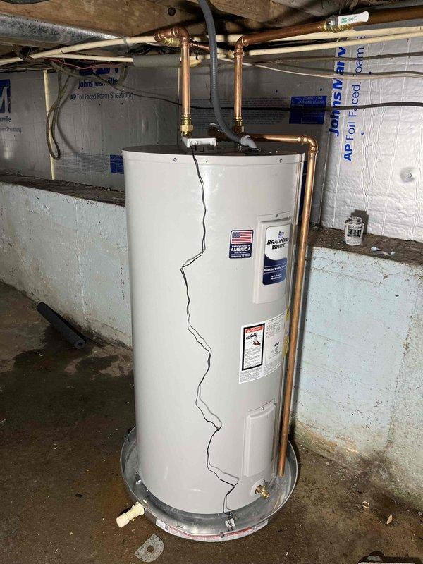 Successfully completed installation of Carrier furnace and white cylindrical water heater in basement utility area. Furnace was properly connected to existing ductwork with metal plenum box and return air system, while water heater was installed with copper piping connections and positioned on a metal drain pan. Both units were tested for proper operation and verified to be functioning correctly.