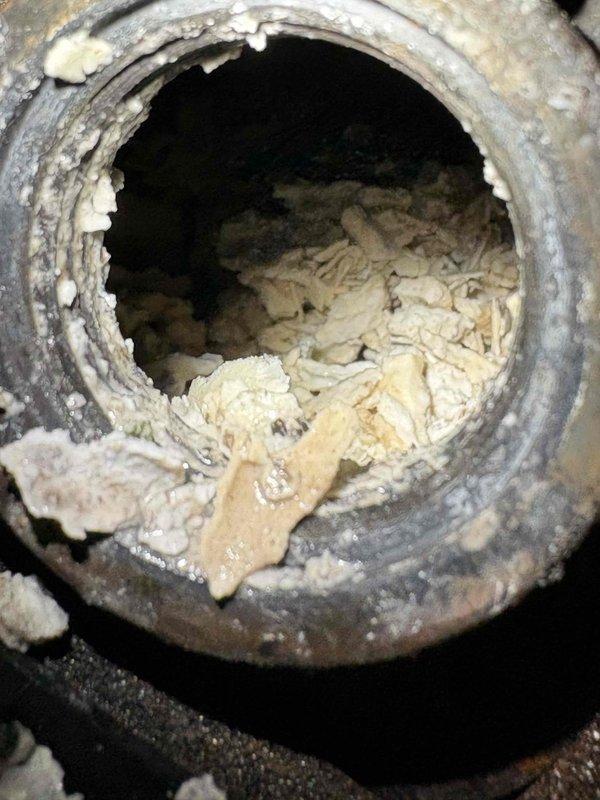 Responded to service call for a leaking 3-year-old Rheem water heater. Inspection revealed severe mineral buildup in drain valve and extensive corrosion on copper pipes. Replaced deteriorated plumbing components and restored proper functionality after addressing the tripped breaker issue.