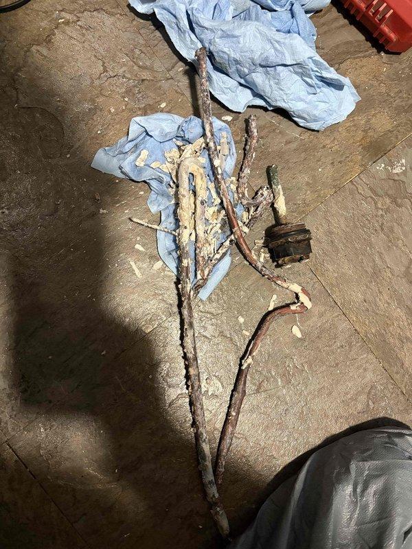 Responded to service call for a leaking 3-year-old Rheem water heater. Inspection revealed severe mineral buildup in drain valve and extensive corrosion on copper pipes. Replaced deteriorated plumbing components and restored proper functionality after addressing the tripped breaker issue.