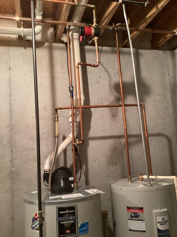 Completed annual heating maintenance service on dual Bradford White water heater system with ENE warranty valid until 10-2028. Performed standard furnace tune-up and humidifier service as part of maintenance club agreement. Visual inspection confirmed proper installation of copper and PVC piping with functional valves and connections; both units operating within normal parameters with no visible issues detected.