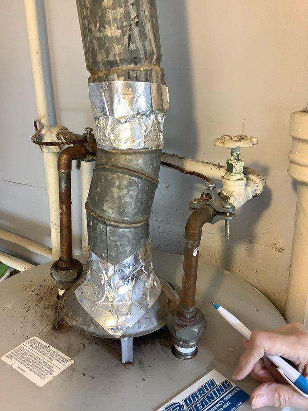 Conducted site assessment for water heater replacement estimate on a 45-year-old unit. Documented existing installation, noting significant corrosion on copper supply lines, deteriorated galvanized piping with foil tape patches, and aging shutoff valves. Photos captured for documentation of current plumbing configuration requiring comprehensive replacement.