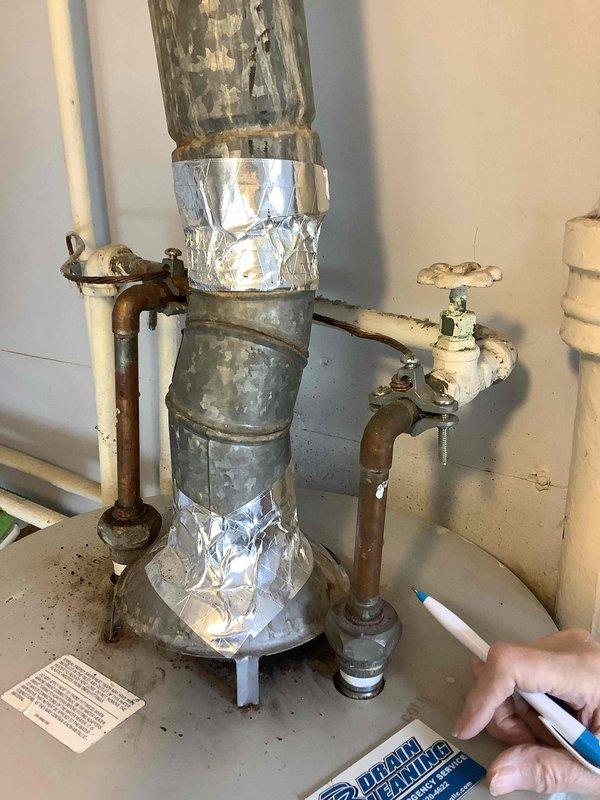 Conducted site assessment for water heater replacement estimate on a 45-year-old unit. Documented existing installation, noting significant corrosion on copper supply lines, deteriorated galvanized piping with foil tape patches, and aging shutoff valves. Photos captured for documentation of current plumbing configuration requiring comprehensive replacement.
