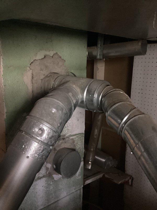 Completed water heater estimate for customer experiencing leakage from existing unit. Inspected current installation including ventilation system, noting damaged wall surface around exhaust piping and examining all plumbing connections. Documented condition of existing tank and surrounding utility area to prepare comprehensive replacement options.