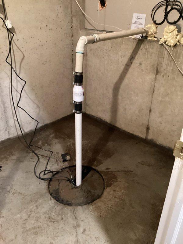 Responded to basement flooding issue caused by malfunctioning sump pump. Inspected the PVC discharge pipe assembly and found standing water in the sump pit. Replaced failed pump, checked electrical connections, and verified proper operation of the new unit to ensure adequate water removal and prevent future basement flooding.