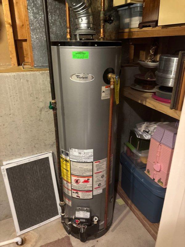 Performed annual furnace tune-up, including inspection of the Whirlpool water heater system with connected copper piping and Y-shaped metal vent configuration. Examined air filter and verified proper ventilation through the ductwork. Customer renewed maintenance agreement for both furnace and AC units.