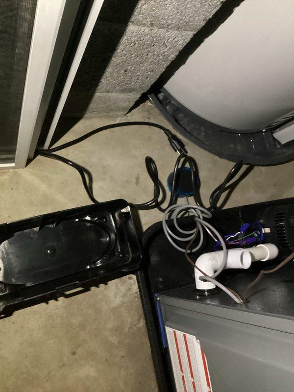 Completed annual tune-up on EnergiAir furnace (2016 model) with integrated humidifier. System is approximately 0 years old. Inspected condensate drainage system, electrical connections, and ductwork - all components functioning properly. Took documentation photos of the installation area showing the furnace unit, PVC drain lines, and connected ductwork in the utility space.