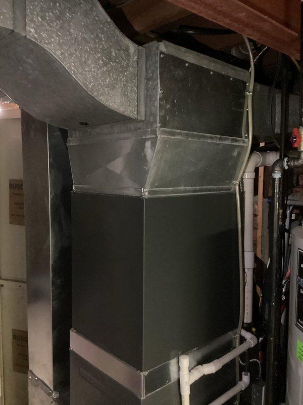 Completed annual tune-up on EnergiAir furnace (2016 model) with integrated humidifier. System is approximately 0 years old. Inspected condensate drainage system, electrical connections, and ductwork - all components functioning properly. Took documentation photos of the installation area showing the furnace unit, PVC drain lines, and connected ductwork in the utility space.