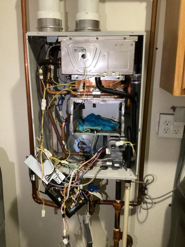 Performed diagnostic assessment on tankless water heater with existing manufacturer warranty. Disassembled unit to inspect heat exchanger components, which showed signs of failure. Documented condition of internal components including copper piping, wiring, and valves for warranty replacement process. Customer has been informed about warranty coverage for complete replacement through our company.