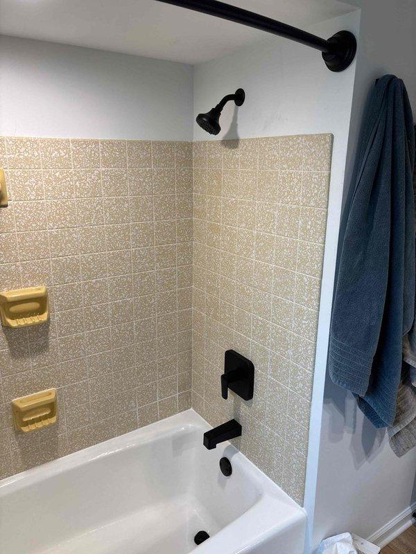 Successfully completed the quoted plumbing repair involving replacement of water shut-off valves. Accessed the plumbing infrastructure through an opening in the wall, where copper supply lines and brass valve assembly were exposed. Work was performed on the bathroom fixtures connected to the bathtub/shower unit with black fixtures.