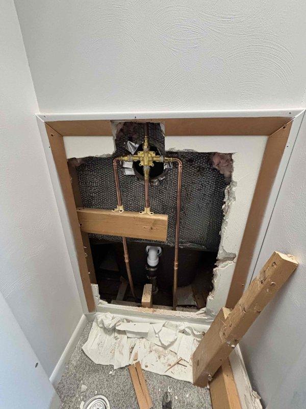 Successfully completed the quoted plumbing repair involving replacement of water shut-off valves. Accessed the plumbing infrastructure through an opening in the wall, where copper supply lines and brass valve assembly were exposed. Work was performed on the bathroom fixtures connected to the bathtub/shower unit with black fixtures.