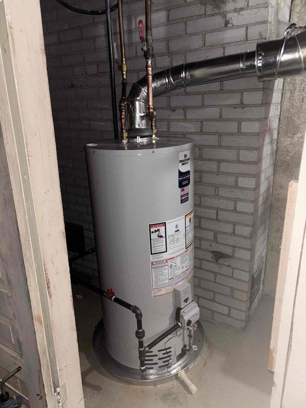 Completed corrections on water heater installation following inspector's rejection. Addressed all three code violations by: clearing the 24" service area in front of the unit, relocating the gas cock to an accessible position, and installing proper combustion air venting to meet code requirements.