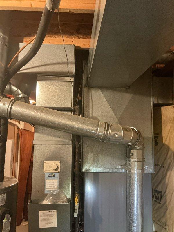 Conducted assessment of 16-year-old furnace and AC system in customer's home, confirming both units are operational but providing inadequate airflow to second story. Visual inspection of basement installation revealed standard residential heating system with connected ductwork in serviceable condition, though likely undersized or improperly balanced for effective multi-level distribution.
