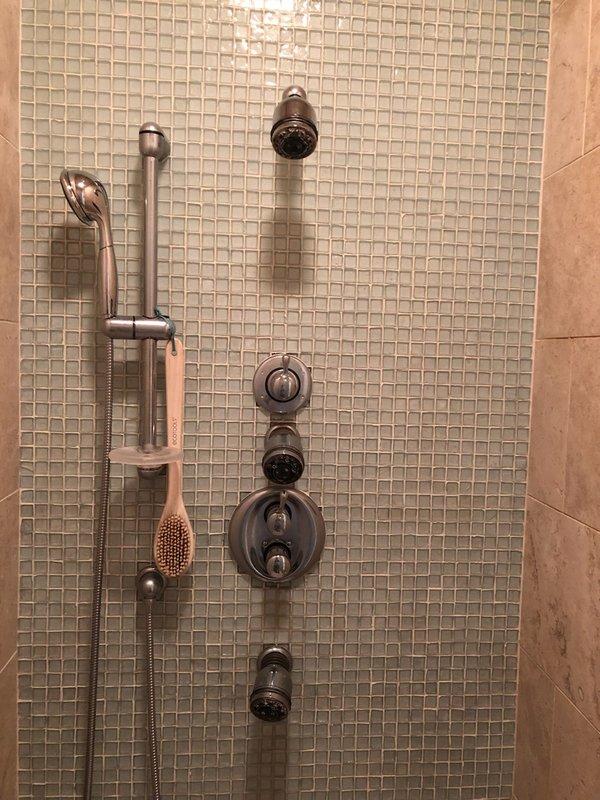 Serviced Kohler temperature control valve in master bathroom shower system featuring multiple shower heads. Diagnosed and repaired non-functioning temperature adjustment mechanism that was allowing only hot water flow. System now provides proper temperature regulation across all four shower heads.