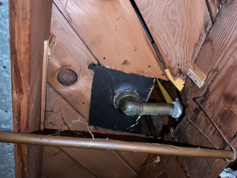 Repaired basement plumbing leak by replacing deteriorated clean-out elbow beneath bathtub that had developed a hole. Inspection revealed mineral deposits and corrosion at connection points, requiring removal of damaged wall material to access and properly seal the affected plumbing components.