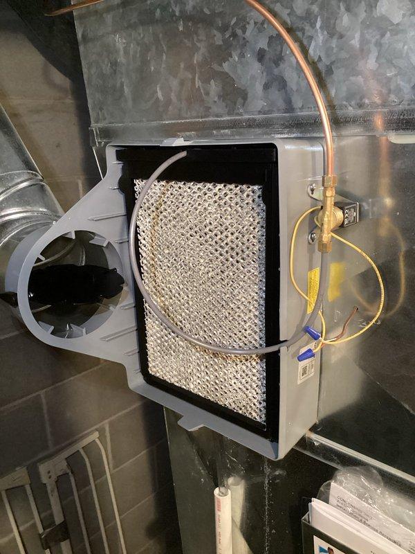 Successfully installed an evaporative humidifier system integrated with existing HVAC ductwork, including proper connection of copper water supply lines and electrical wiring. Manual humidistat was temporarily installed with note that replacement unit will be provided during follow-up service.