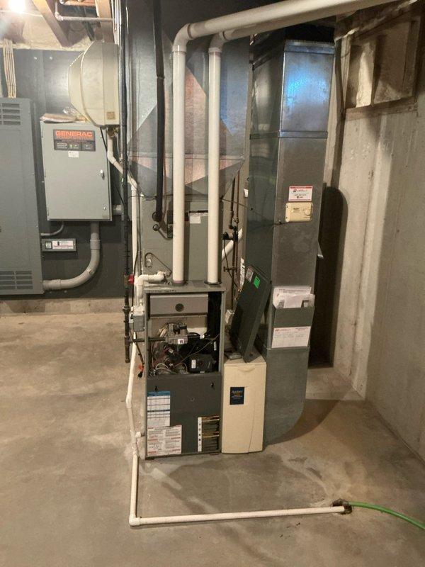 Completed replacement estimate for 20-year-old furnace and AC system in single-family residence. Documented existing electrical control panel featuring InPhase Monitor Control system with utility monitoring capabilities. Inspected basement mechanical room housing aging furnace with exposed control wiring and ventilation components, noting proximity to Generac backup power system.