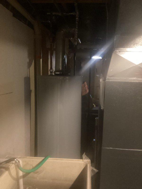 Completed installation of new furnace and air conditioning system in basement utility area. System was properly connected to existing ductwork and plumbing infrastructure with all necessary venting installed. Final inspection confirmed proper operation of both heating and cooling components.