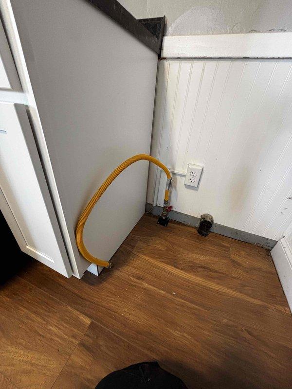 Performed gas line inspection and assessment at property accessed via rear entrance (code 0657). Evaluated existing CSST yellow gas line installation and connection to valve fitting in corner area with beadboard paneling. Documented current setup with photos and provided detailed repair estimate for minor gas line modifications needed for safe appliance operation.