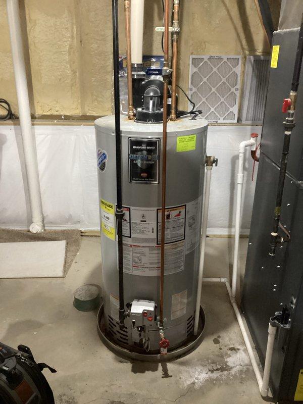 Conducted estimate for leaking water heater that is not producing hot water. Existing unit is a cylindrical metallic water heater with copper pipes connected to top section, installed in basement utility area. Inspected associated plumbing infrastructure including PVC piping, brass valves, and connections to determine replacement requirements.