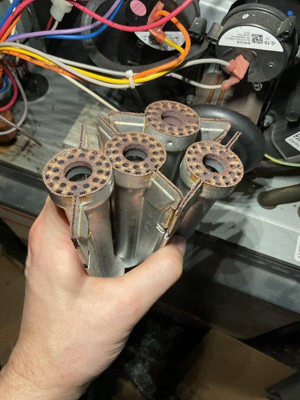 Performed annual heating system maintenance on customer's furnace. Inspected burner assembly which showed significant corrosion and rust on the burner heads. Noted additional corrosion issues on internal components and inspected wiring connections and pressure switch functionality. Completed standard tune-up procedures to ensure proper operation for the heating season.