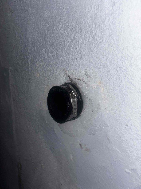 Repaired leaking pipe fitting in wall by replacing faulty rubber gasket and securing with new stainless steel hose clamp. Inspected surrounding area for water damage and confirmed proper sealing of the connection to prevent future moisture intrusion.