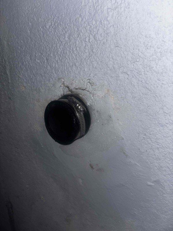 Repaired leaking pipe fitting in wall by replacing faulty rubber gasket and securing with new stainless steel hose clamp. Inspected surrounding area for water damage and confirmed proper sealing of the connection to prevent future moisture intrusion.