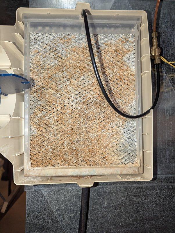 Responded to water leak issue with 21-year-old Aprilaire humidifier. Inspection revealed severely corroded water supply pipe with significant rust damage, causing the reported leak. Documented condition with photos showing deteriorated filter assembly and damaged supply line.
