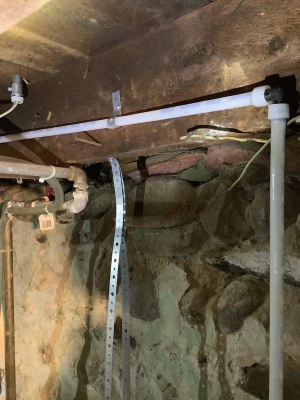 Completed quoted repair job involving replacement of upstairs kitchen water supply lines and PVC drain pipes in a residential property. Work included installation of new PVC drainage components and water supply lines, properly secured with metal brackets to floor joists in the basement/crawlspace area. All connections were tested to ensure proper function and absence of leaks.