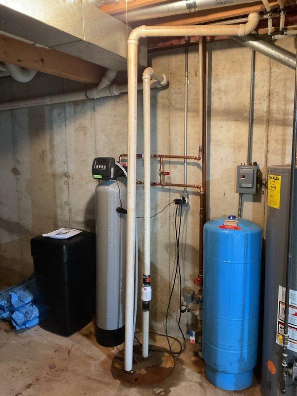 Installed and configured a water softener system in customer's basement. Setup included connecting the main unit with digital control head to existing copper plumbing with appropriate valves, and ensuring proper drainage via clear tubing. System was tested and operational, with the control head programmed and displaying correct time.