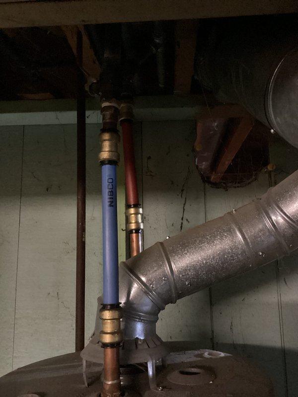 Conducted a water heater evaluation in response to customer's request for an estimate, noting their concerns about a possible thermocouple issue. Upon inspection of the existing unit, observed aging components and examined the current installation including ventilation, supply lines, and connections. Documented the system configuration with photographs for accurate replacement sizing and specification purposes.