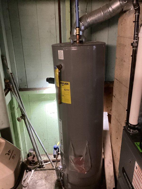 Conducted a water heater evaluation in response to customer's request for an estimate, noting their concerns about a possible thermocouple issue. Upon inspection of the existing unit, observed aging components and examined the current installation including ventilation, supply lines, and connections. Documented the system configuration with photographs for accurate replacement sizing and specification purposes.