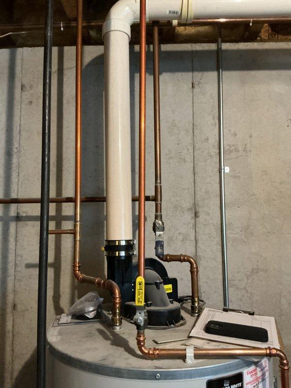 Conducted water heater estimate for customer (CWOW) in basement utility area. Photographed existing installation showing copper and PVC piping connections, valves, and current unit placement adjacent to storage shelving. Documentation completed for potential replacement of residential hot water system under CM 2025.