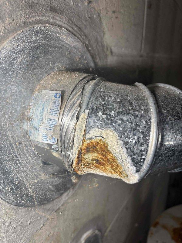 Conducted comprehensive inspection of existing 40-gallon natural draft water heater showing severe corrosion at copper pipe connections and significant rust formation on top surface. Documented extensive oxidation at pipe joints with photographic evidence, indicating potential leaks and end-of-life condition requiring replacement.