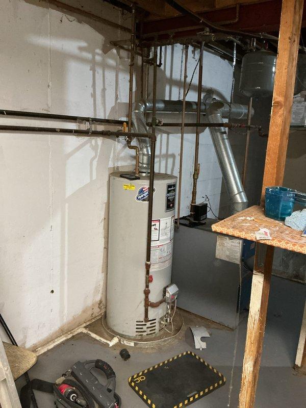 Responded to no hot water complaint on 13-year-old Bradford White water heater. Inspected unit and ventilation system, focusing on the vent pipe connection through the wall which showed signs of wear and improper sealing. Repaired flue connection and restored hot water functionality to the system.