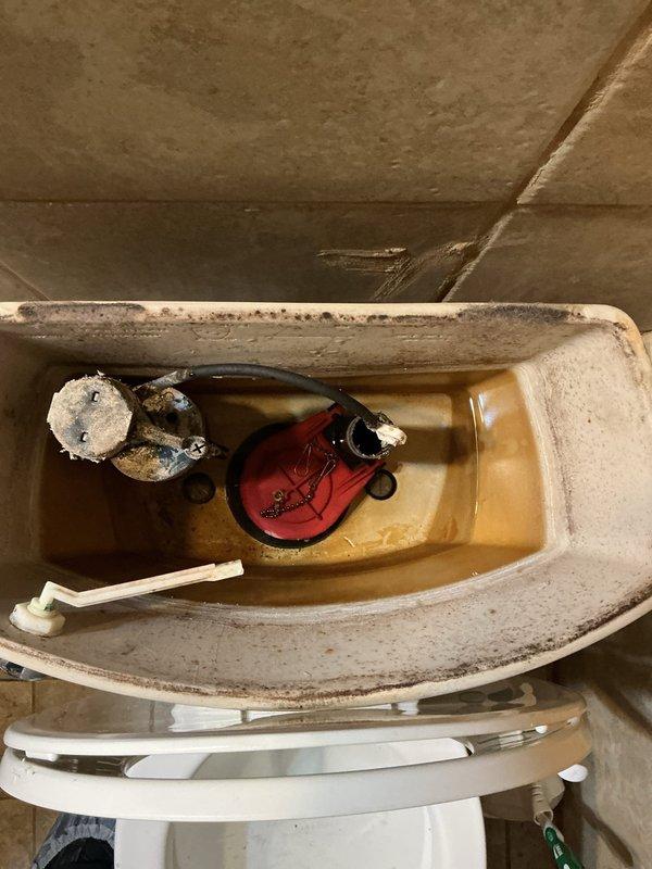 Diagnosed and repaired toilet with improper flushing and handle leak; replaced worn ballcock assembly and flush valve which had significant mineral buildup causing the malfunction. Verified proper water level and tested flush operation after installation of new components.