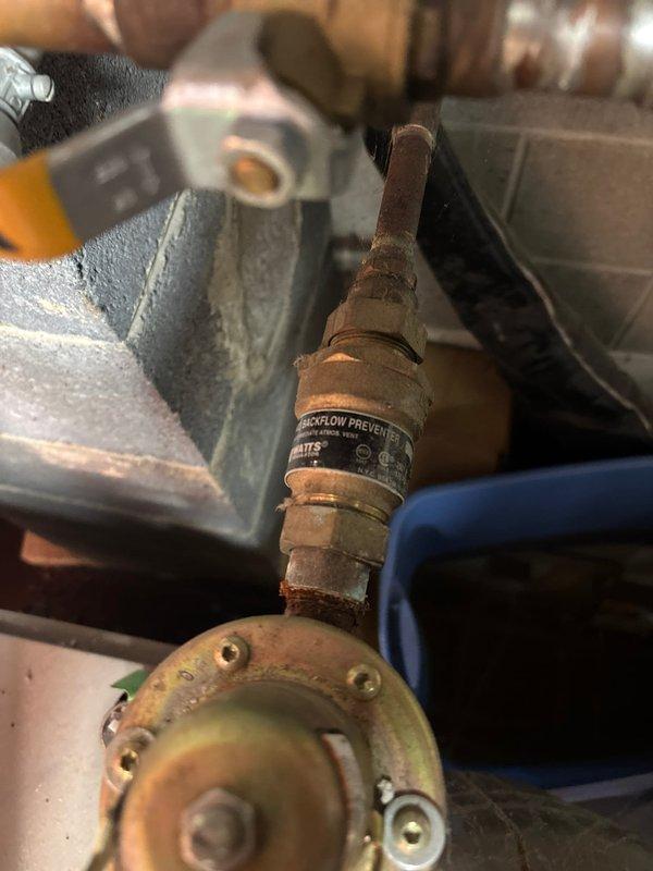 Replaced faulty shower faucet exhibiting significant corrosion and oxidation on copper pipe connections. Installed new backflow preventer valve with proper fittings and verified proper operation of the yellow-handled shutoff valve. Documented repair with photos showing completed installation with all components securely connected to the existing plumbing system.