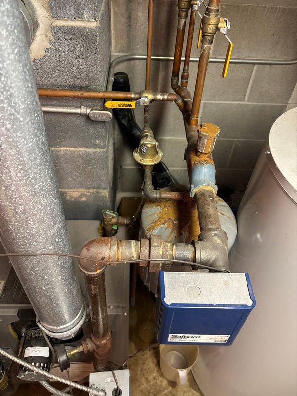 Replaced faulty shower faucet exhibiting significant corrosion and oxidation on copper pipe connections. Installed new backflow preventer valve with proper fittings and verified proper operation of the yellow-handled shutoff valve. Documented repair with photos showing completed installation with all components securely connected to the existing plumbing system.