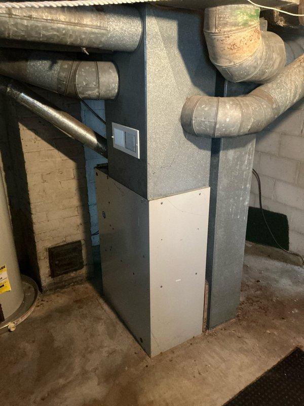 Conducted furnace estimate for 16-year-old non-operational heating system located in basement utility room. Unit showed significant age-related wear with visible dust and discoloration on ductwork. Recommended replacement due to age and condition of equipment.