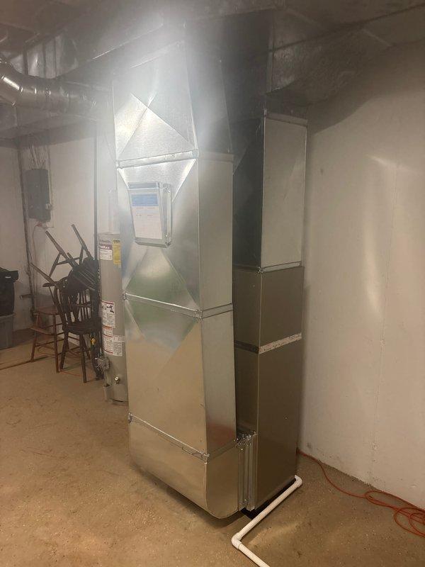 Successfully completed installation of a new residential HVAC system, including an outdoor air conditioning condensing unit mounted on a concrete pad with proper electrical connections and a high-efficiency furnace in the utility room with all required ductwork connections. System was fully tested and verified operational with all components properly secured and installed according to manufacturer specifications.