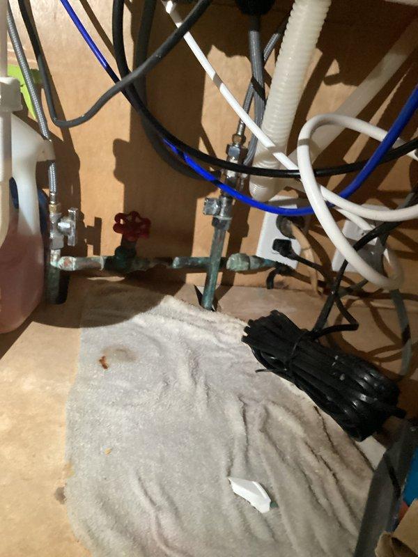 Responded to emergency call for a burst pipe causing complete water loss to residence. Located leak at appliance connection point showing signs of water damage and residue buildup. Isolated system using the red-handled shutoff valve, replaced damaged section of pipe, and verified proper water flow restoration with no further leakage. System now functioning normally with all house water service restored.