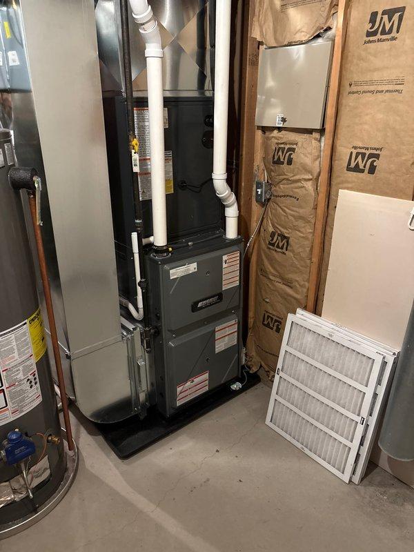 Successfully installed new furnace and air conditioning system in residential mechanical room. Complete installation included proper venting with PVC pipes, placement of the furnace on a drain pan for condensate management, and connection to existing ductwork. System was tested and verified to be in proper working condition with all safety labels affixed and replacement air filters provided.