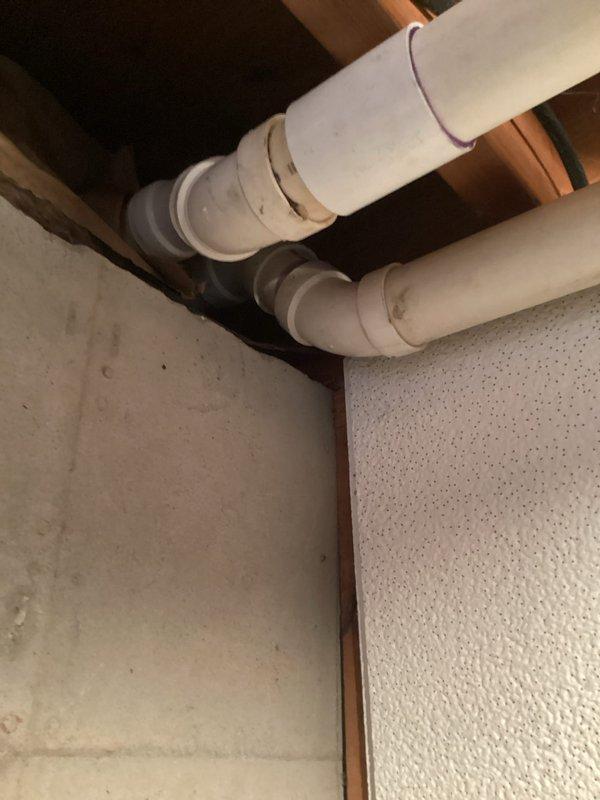 Responded to service call for loose PVC exhaust pipe at a joint on a 3-year-old ENE Wt 08-2028 system. Inspected the PVC ventilation assembly where pipes connect at 90-degree turns, identified a compromised joint with purple primer markings, and properly resealed the connection to restore system integrity and proper venting function.