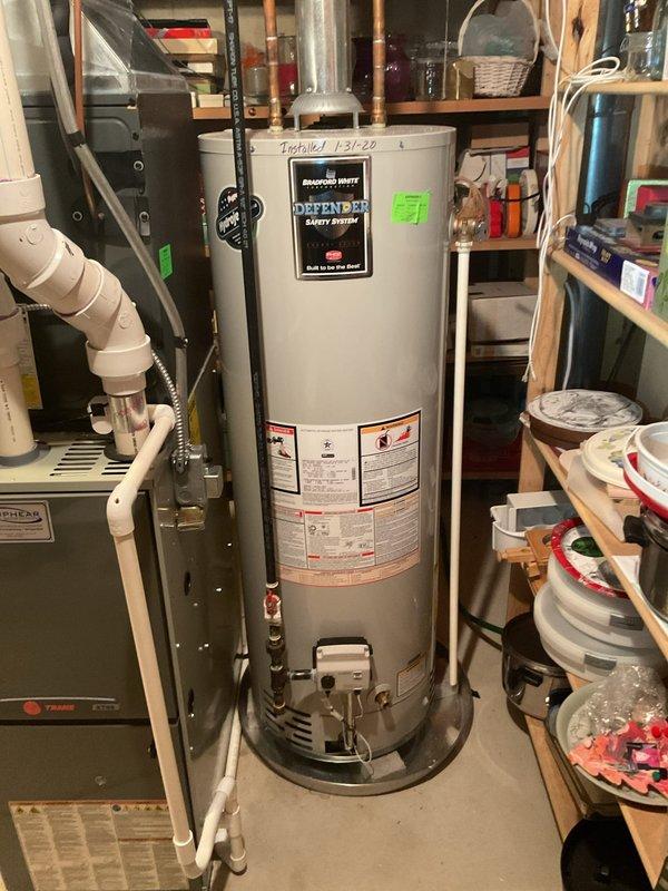 Completed water heater estimate for a 26-year-old system requiring replacement. Customer requesting urgent installation with existing unit being a Bradford White "Defender Safety System" model showing installation date of 1-31-20. Assessment included evaluation of current connections, piping configuration, and available space in the utility area for proper replacement.