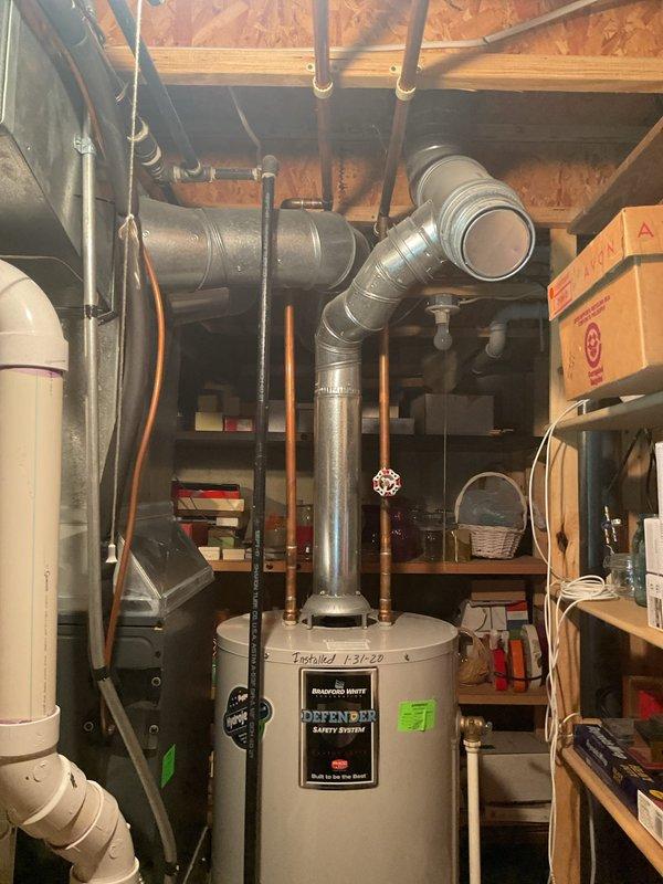 Completed water heater estimate for a 26-year-old system requiring replacement. Customer requesting urgent installation with existing unit being a Bradford White "Defender Safety System" model showing installation date of 1-31-20. Assessment included evaluation of current connections, piping configuration, and available space in the utility area for proper replacement.