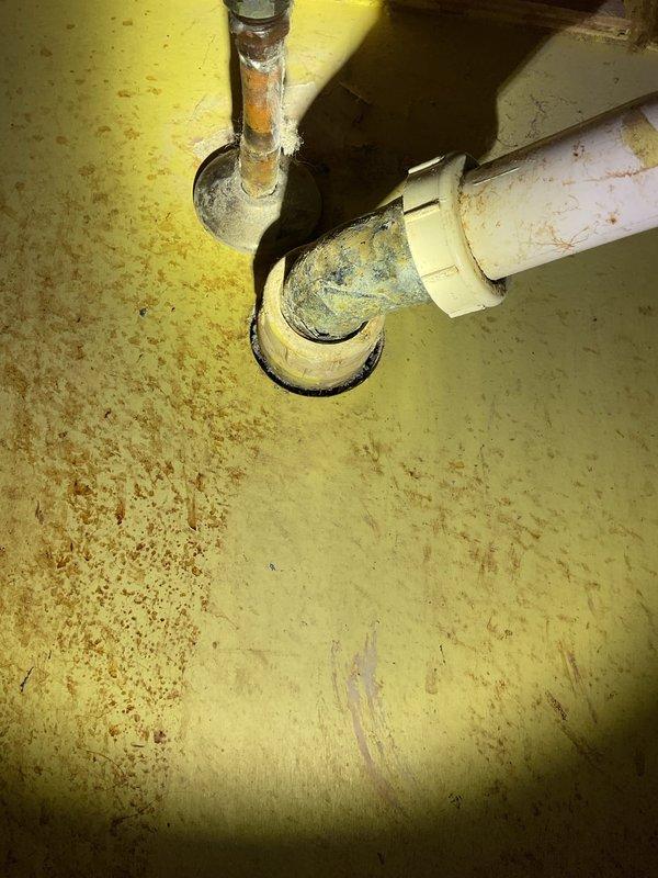 Replaced severely corroded metal pipe under bathroom sink that had developed a quarter-size hole causing active leakage. Installed new PVC P-trap assembly with proper connections to existing drain line, successfully eliminating the leak and restoring proper drainage function.
