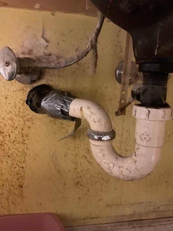 Replaced severely corroded metal pipe under bathroom sink that had developed a quarter-size hole causing active leakage. Installed new PVC P-trap assembly with proper connections to existing drain line, successfully eliminating the leak and restoring proper drainage function.