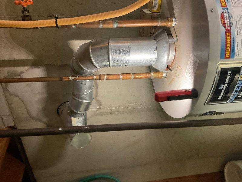 Performed annual heating tune-up, inspecting water heater installation including proper connection of copper pipes, ventilation ducting, and safety valve. Confirmed proper installation of metal duct through concrete floor with appropriate flashing and seal at the base. System is functioning within normal parameters.