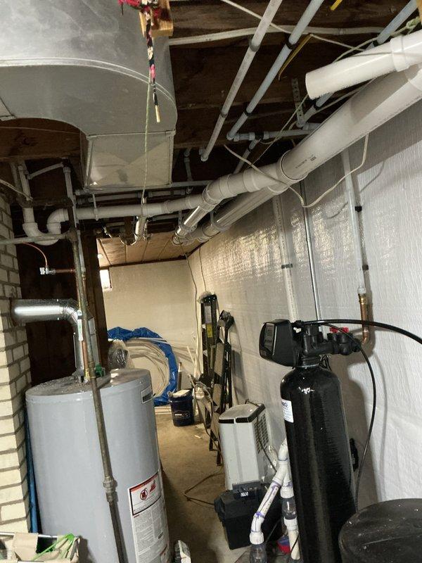 Completed comprehensive drain and water repipe project in basement utility area, installing new PVC drainage lines and water supply piping along ceiling joists. Successfully connected all plumbing to existing water heater and filtration system while ensuring proper alignment and secure fastening of all components throughout the system.